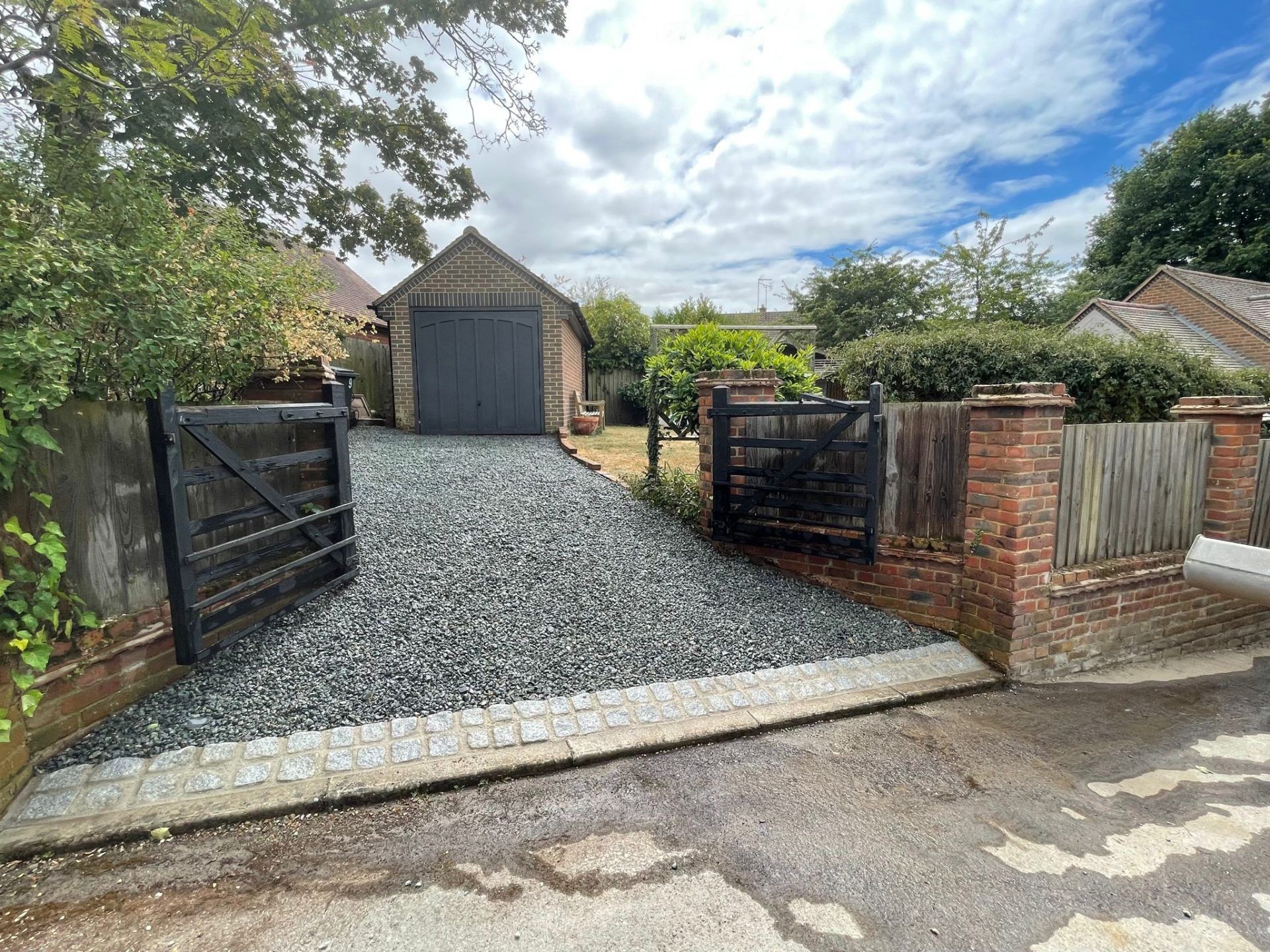 View towards single garage over newly laid chippings driveway.