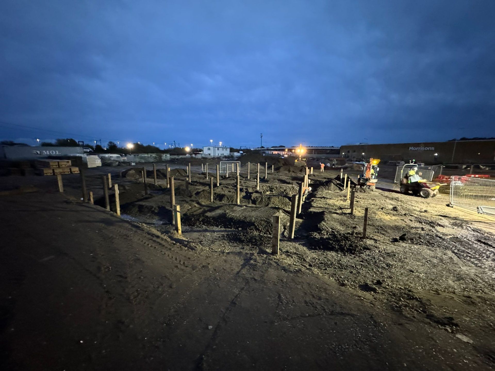 Floodlit view of building site with mechanical diggers.